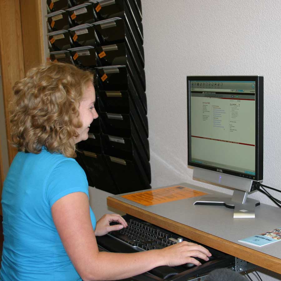Woman sitting in front of computer in computer lab
