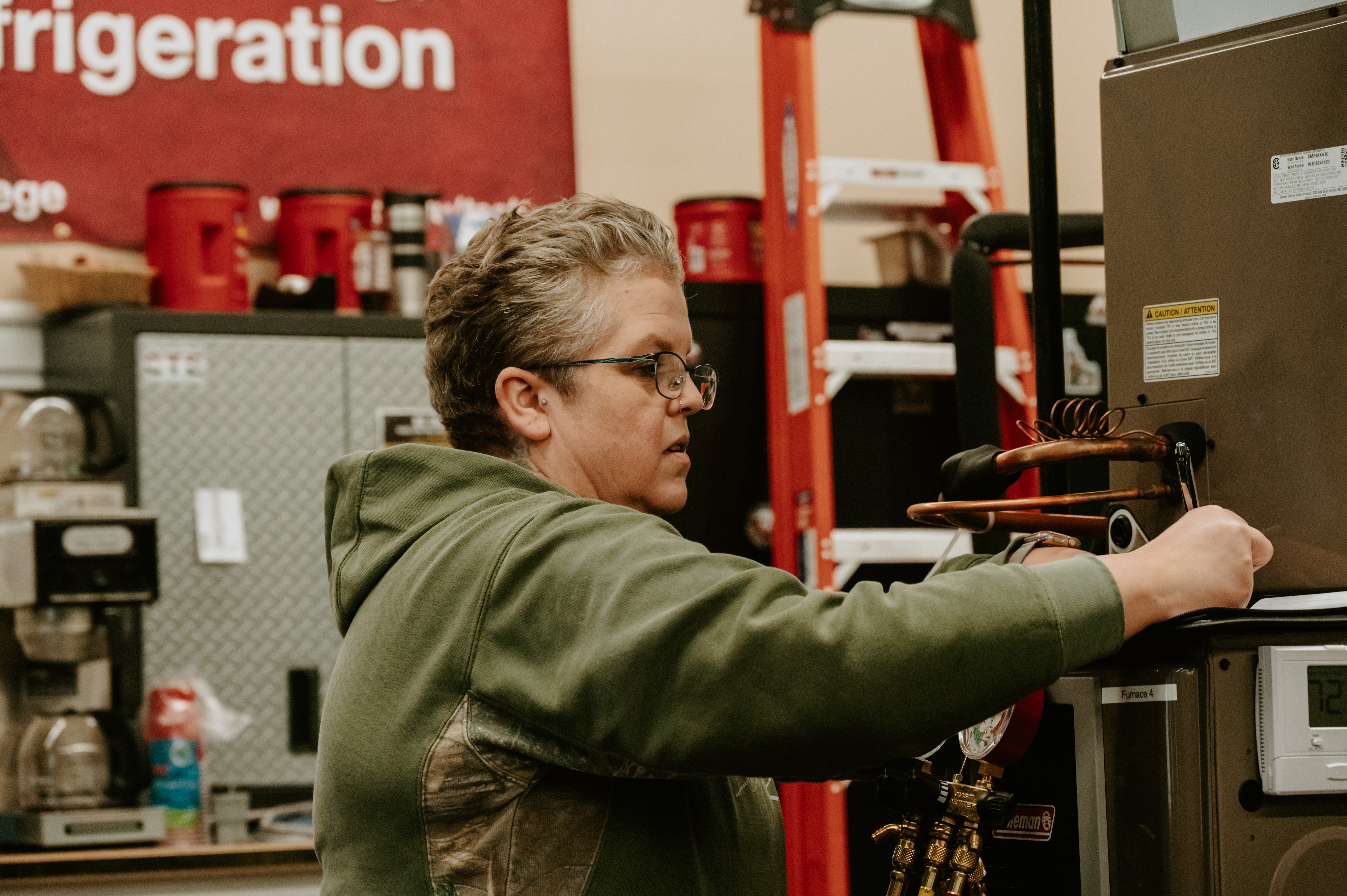 Older woman student learning how to use a HVAC system