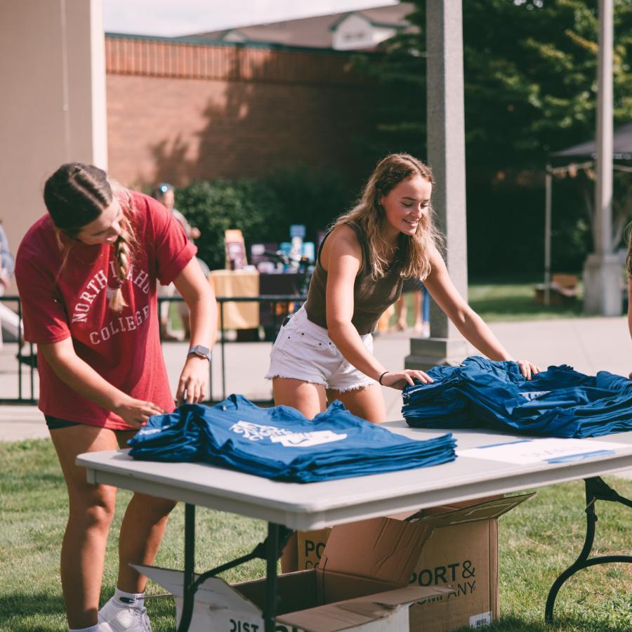 2 students setting up tshirts on table