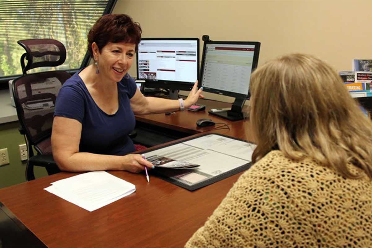 Academic counselor meeting with a student about classes