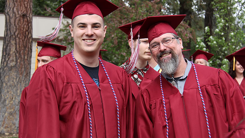 Two veteran students in red graduation robes