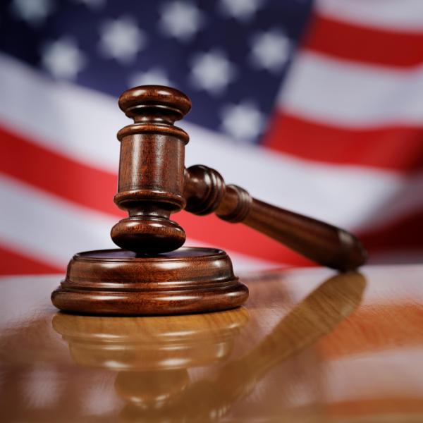 close-up-gavel-wooden-table-against-american-flag-wide.