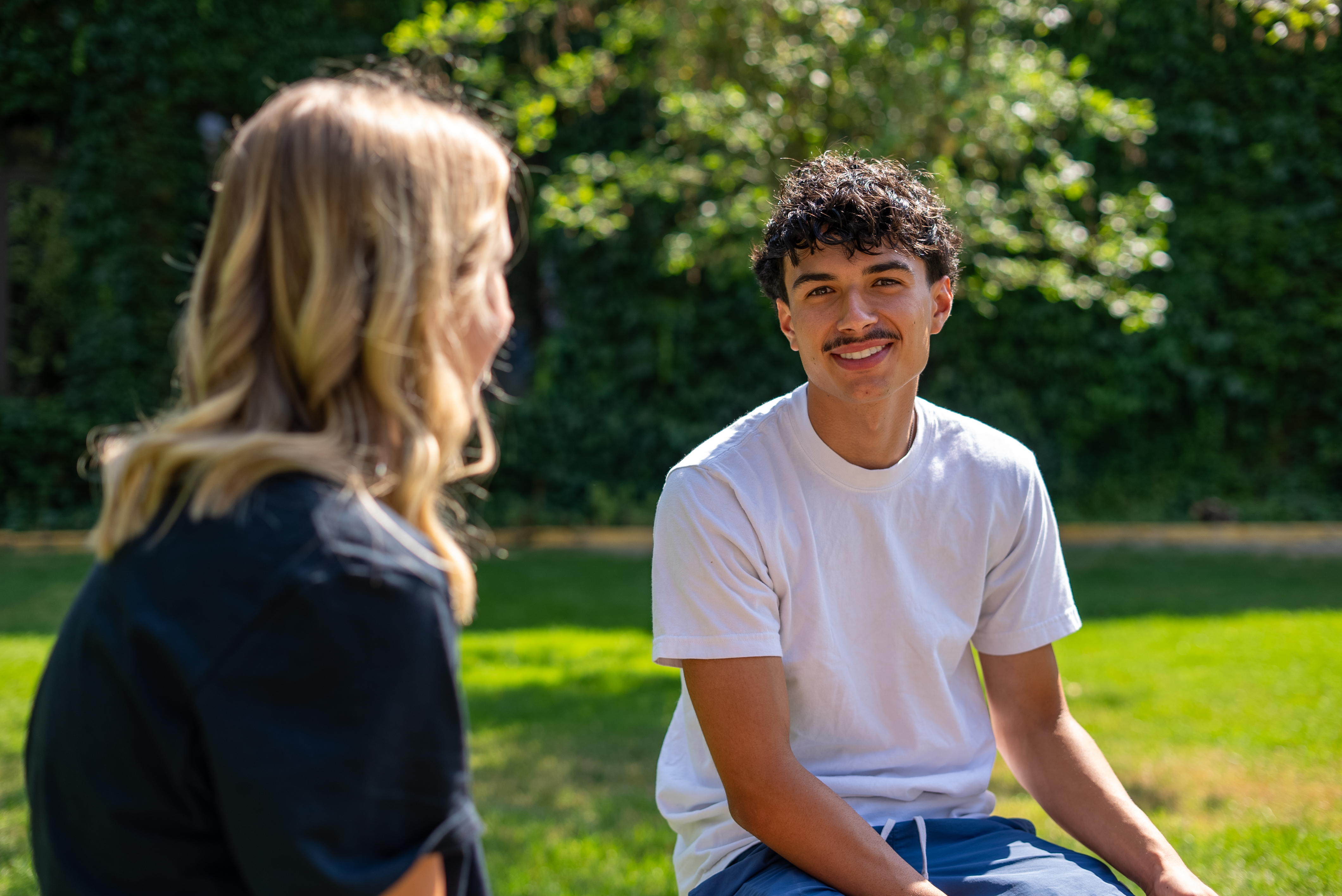 Male student sitting outside with female student