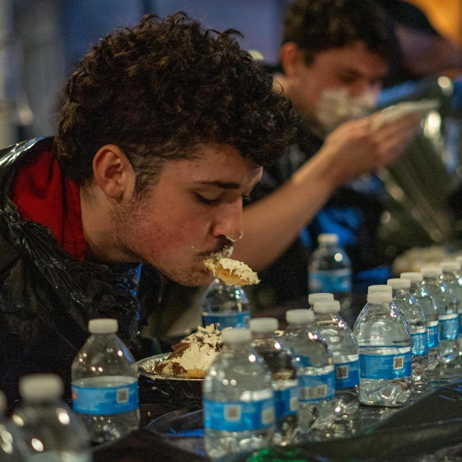 Student eating a Pie at a pie eating contest at the dorms