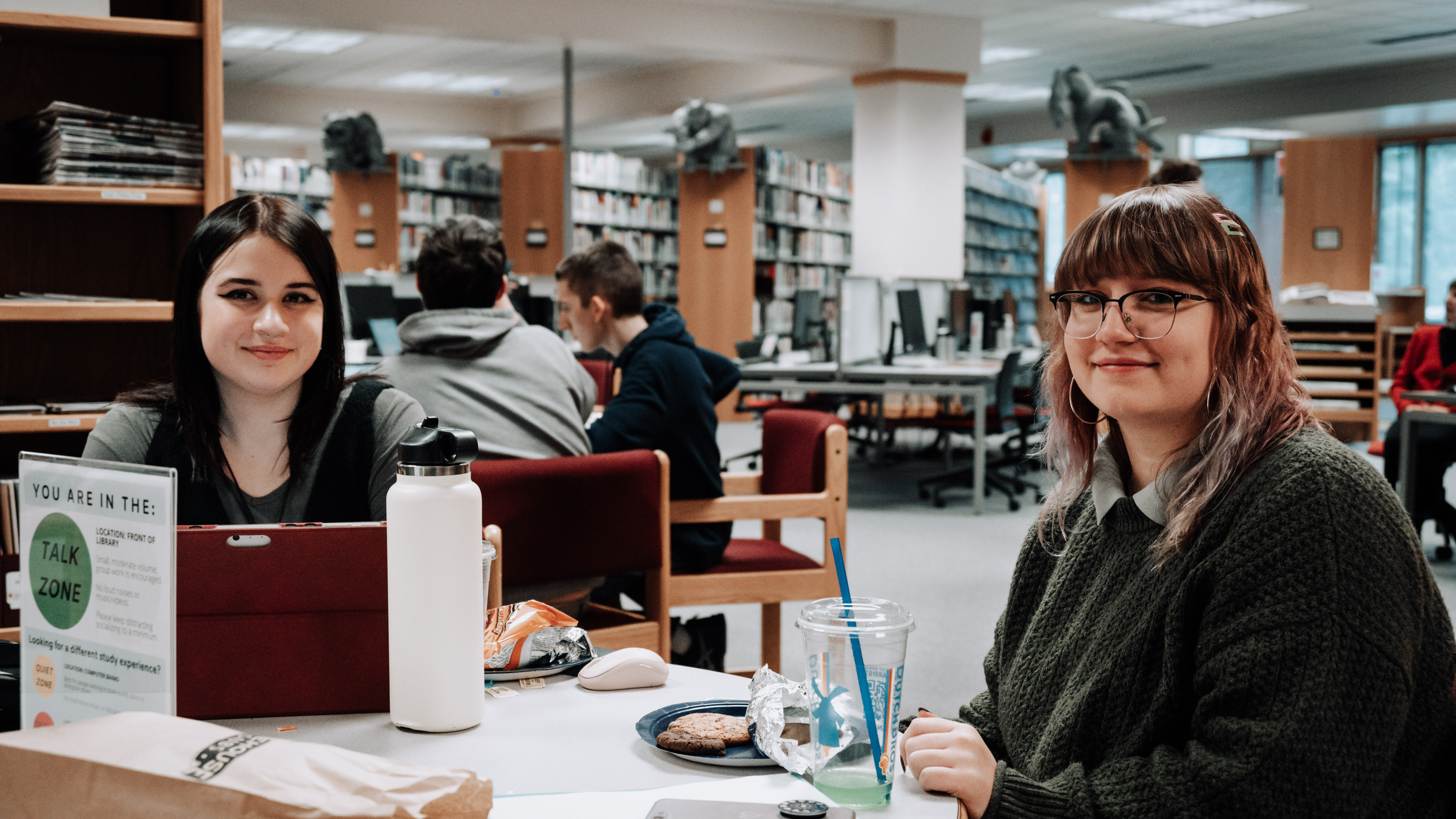 900x900 female student eating and studying in library