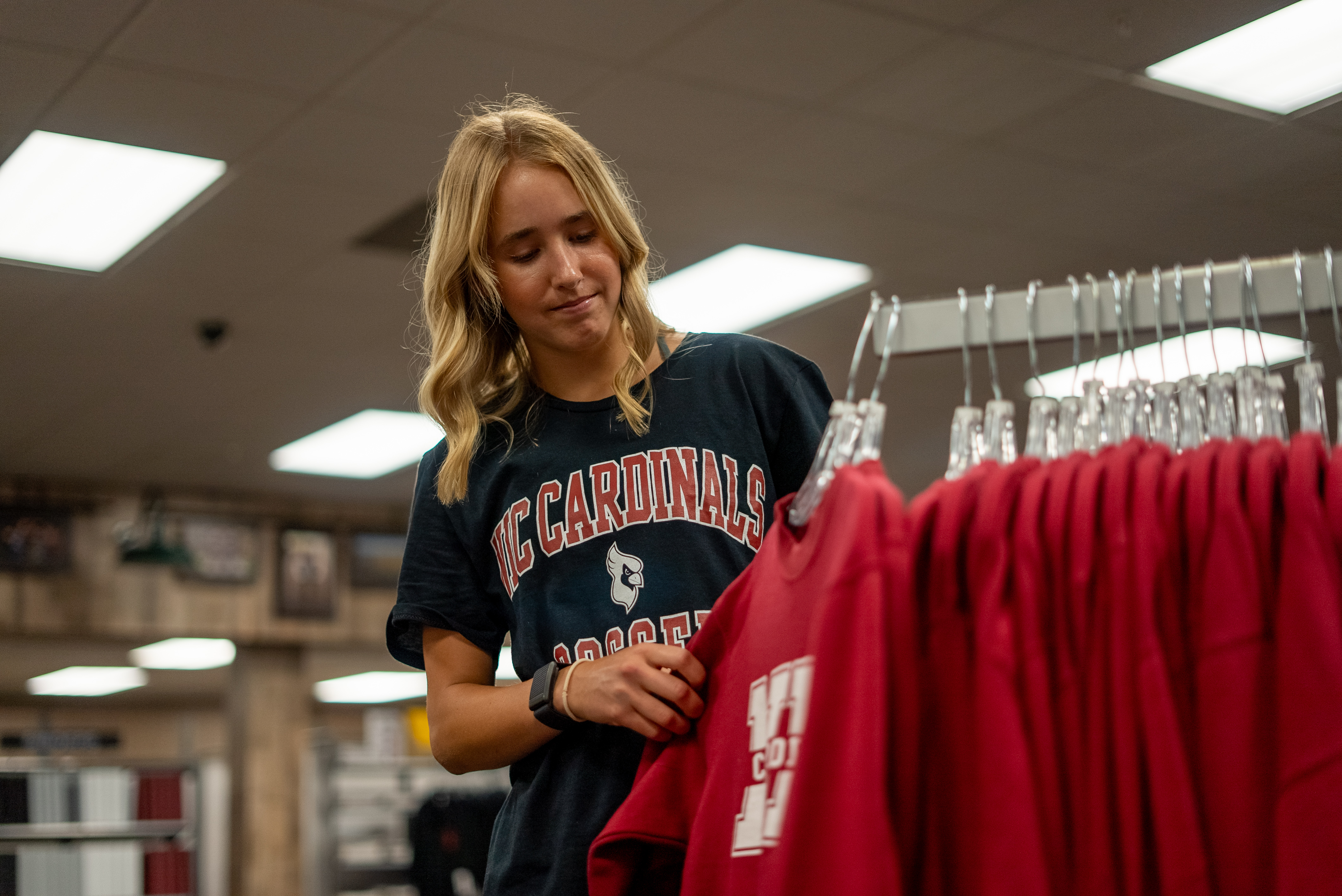  female student in the college bookstore looking at sweatshirts