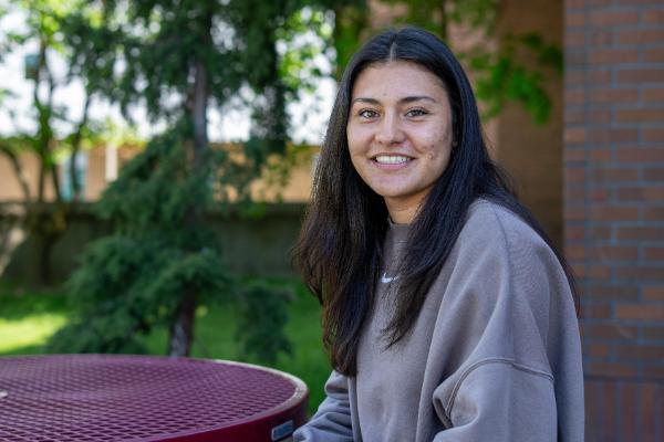 Female student sitting at a table outside