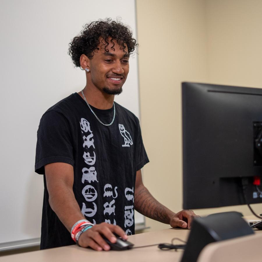 Male standing at standing desk working on computer