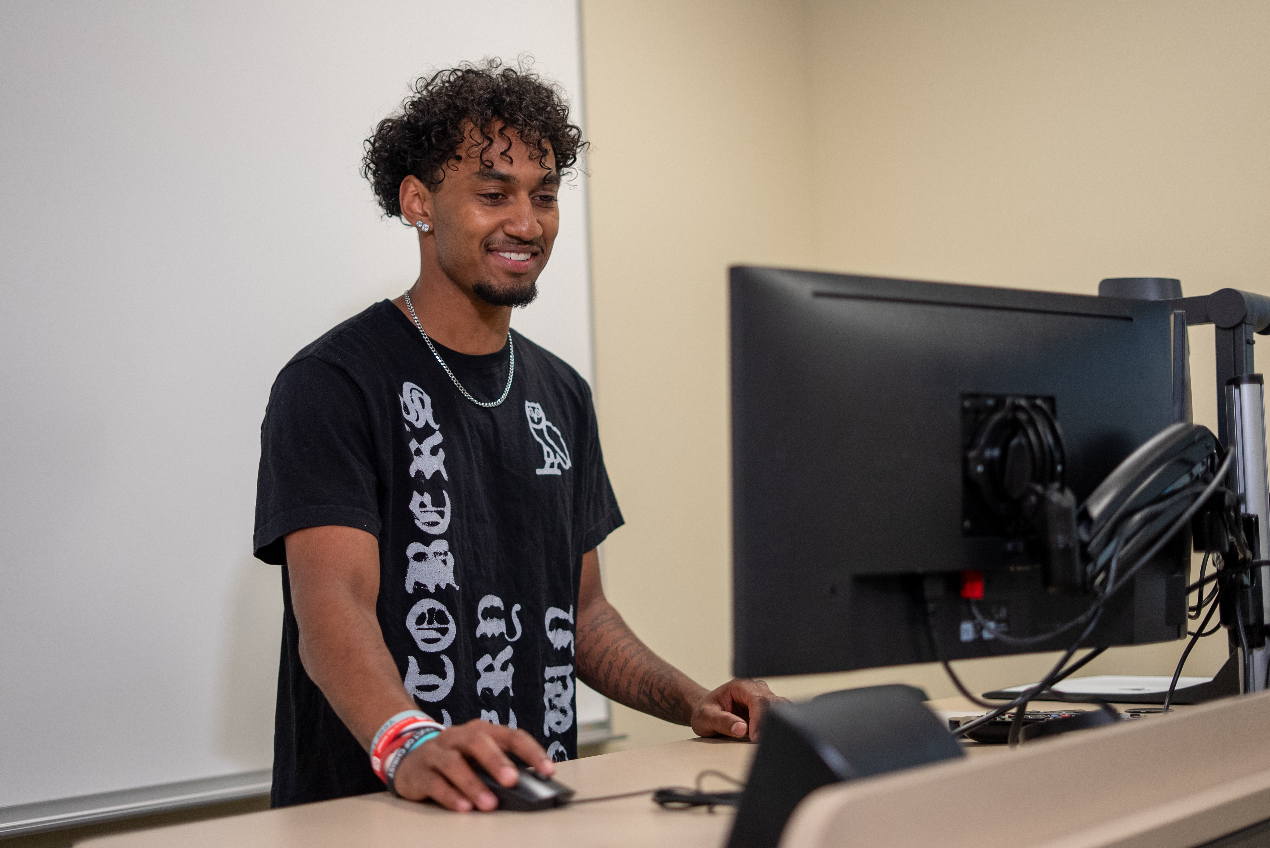 Male standing at standing desk working on computer