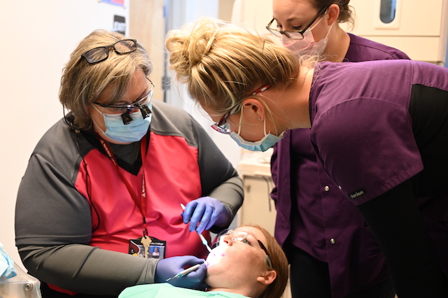 Dental Health students practicing while being instructed by professor