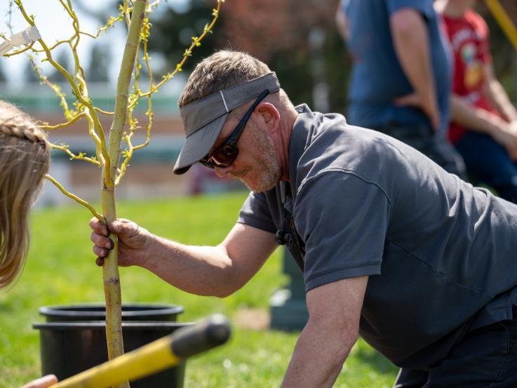 NIC Landscape Technician J.D. Reeves plants a tree on April 29, 2023 during NIC’s drive-thru Arbor Day event at NIC’s Coeur d’Alene campus.