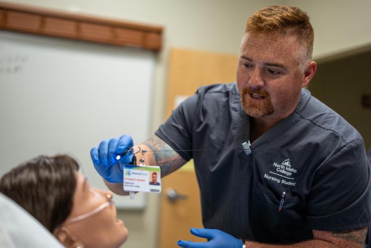 Male Nursing Student doing clinicals on a maniquin