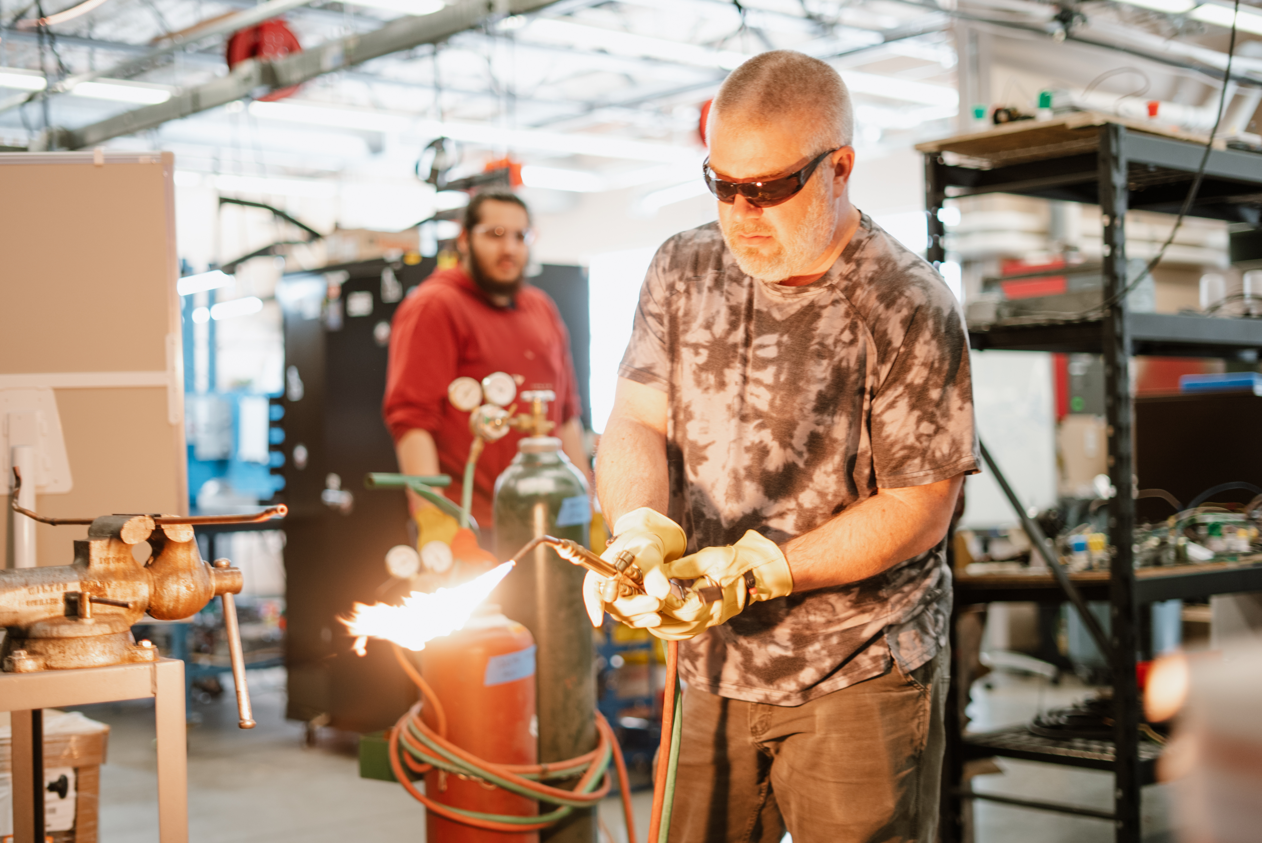 student operating a blow torch