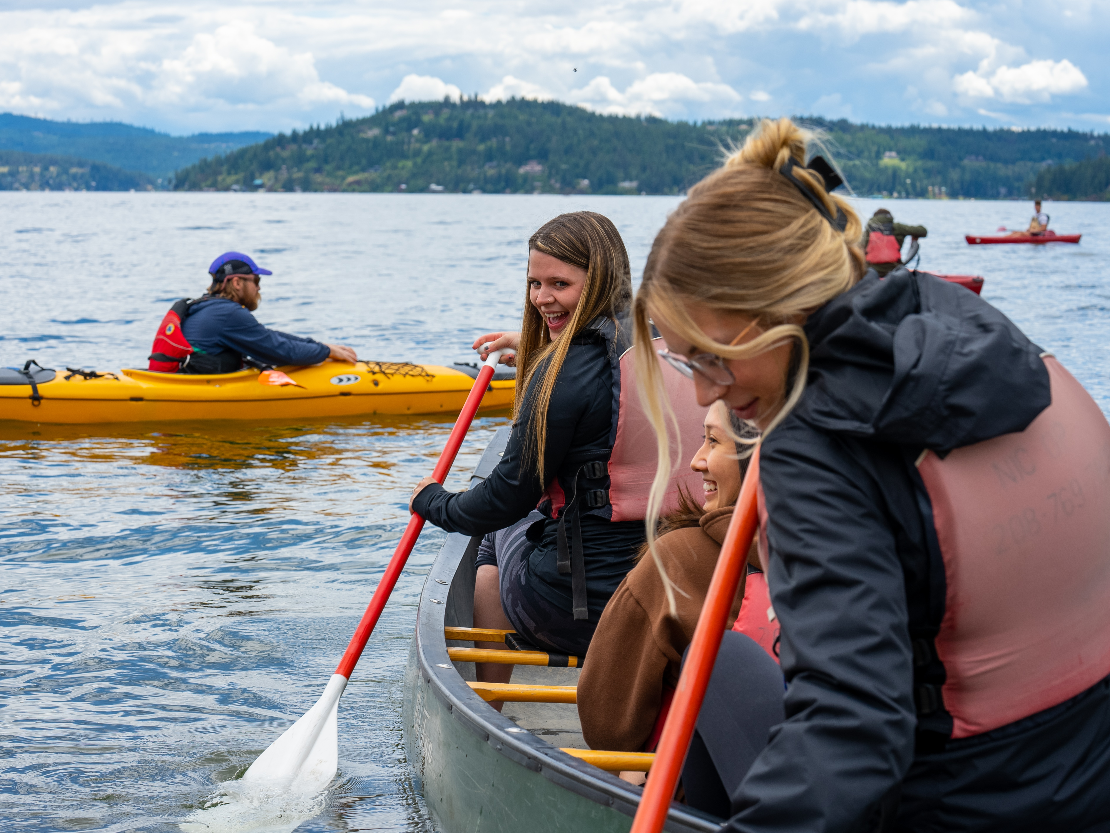 3 students in a canoe on a lake