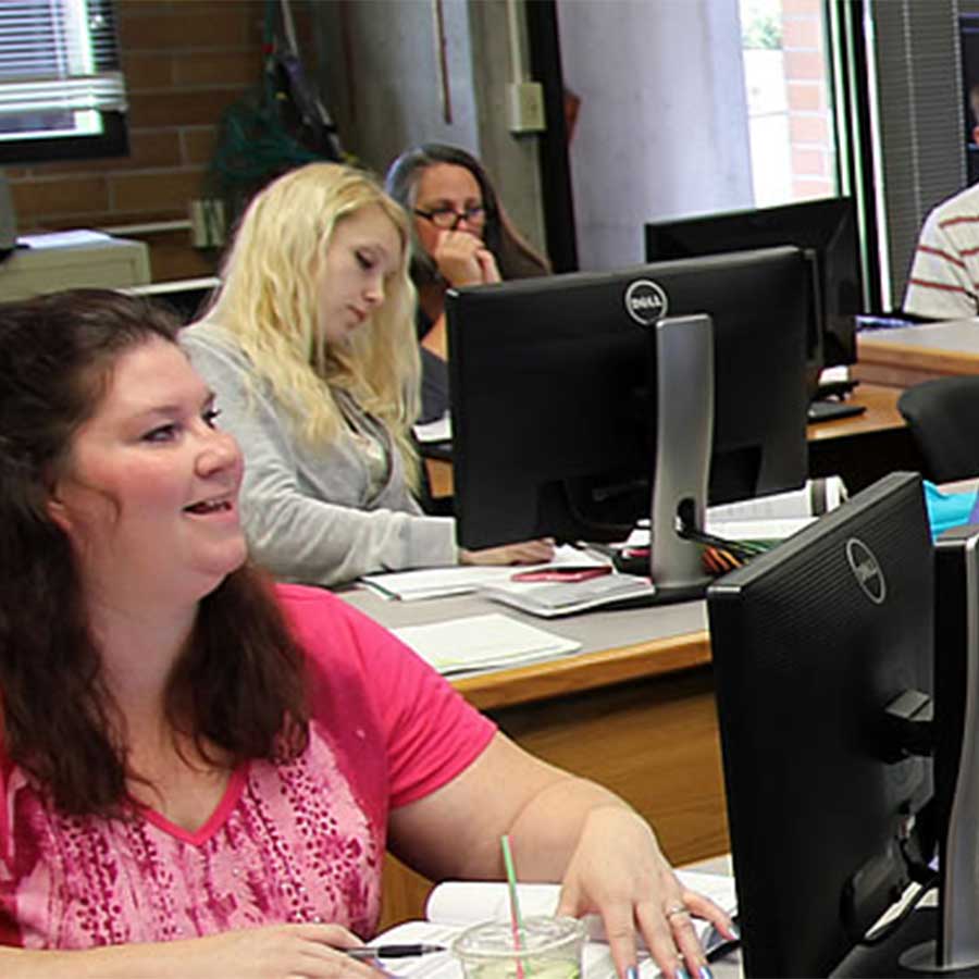 Students sitting in class at computers studying accounting