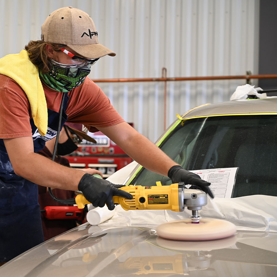 Student polishing the hood of a car