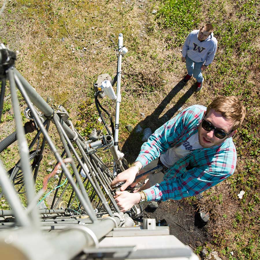 Engineering students working on a radio tower in the field