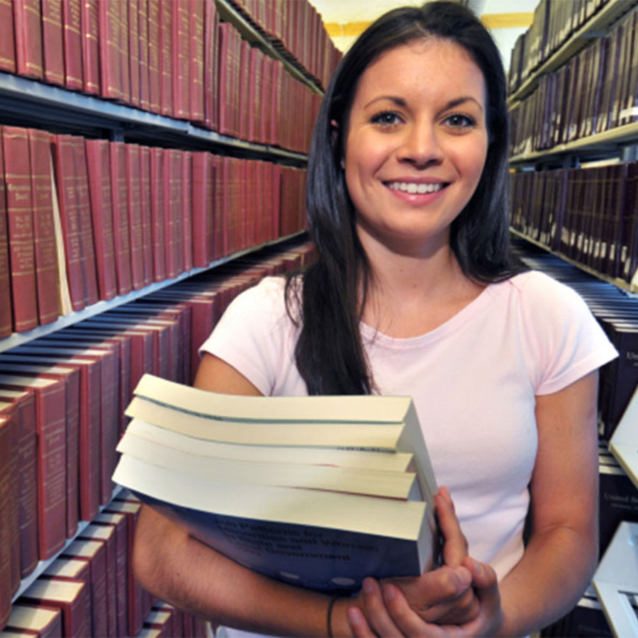 Young woman standing in an isle at the library