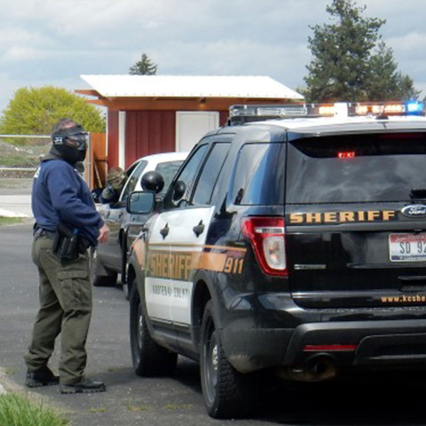 Law enforcement students next to police vehicle