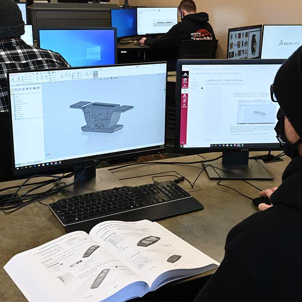 Student designing parts in 3d program on the computer