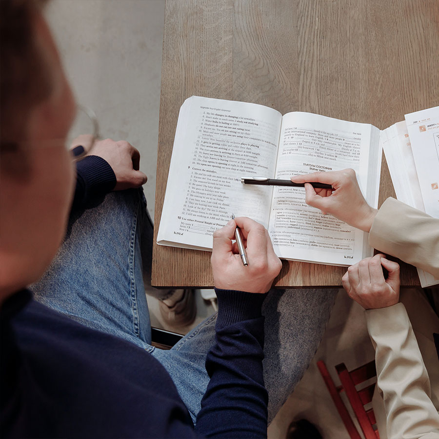 Two students studying foreign languages in a textbook