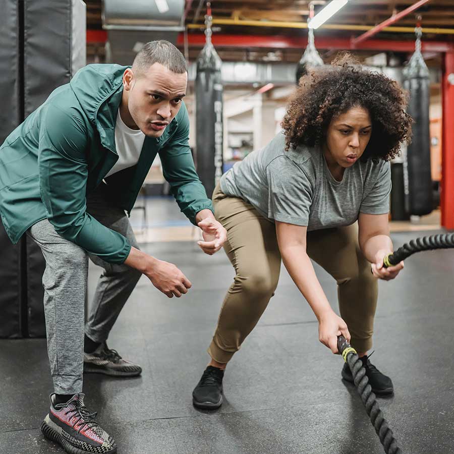 Personal trainer working with his client in the gym