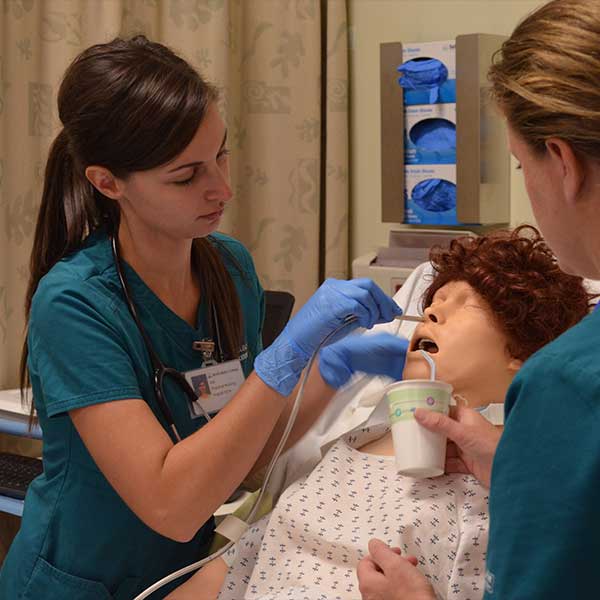 Practical Nurses working with a dummy patient