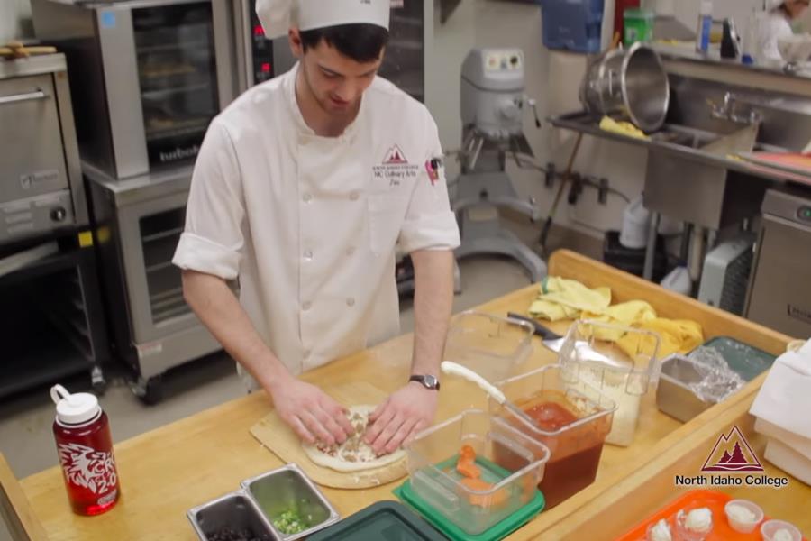 Student working on making a pizza